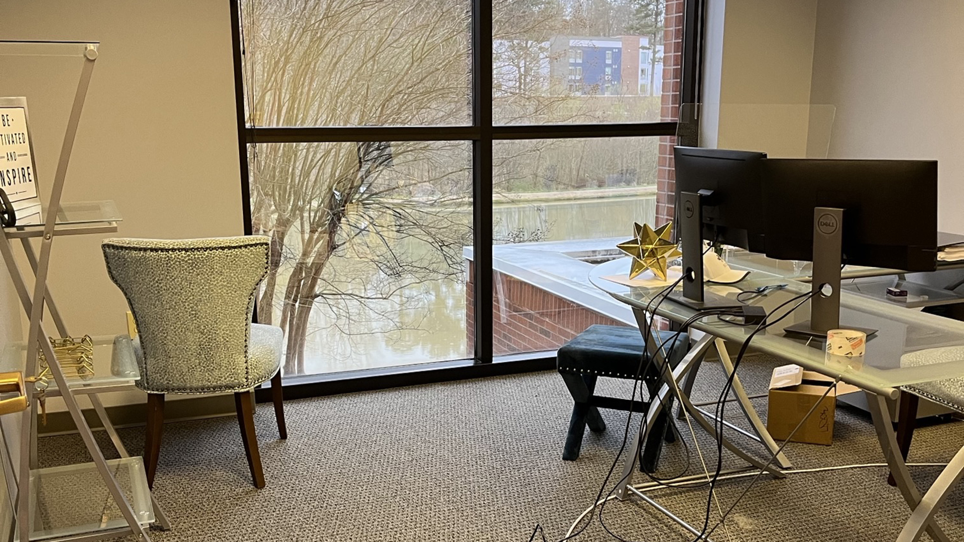 Image of private office with glass desk furniture and floor to ceiling window