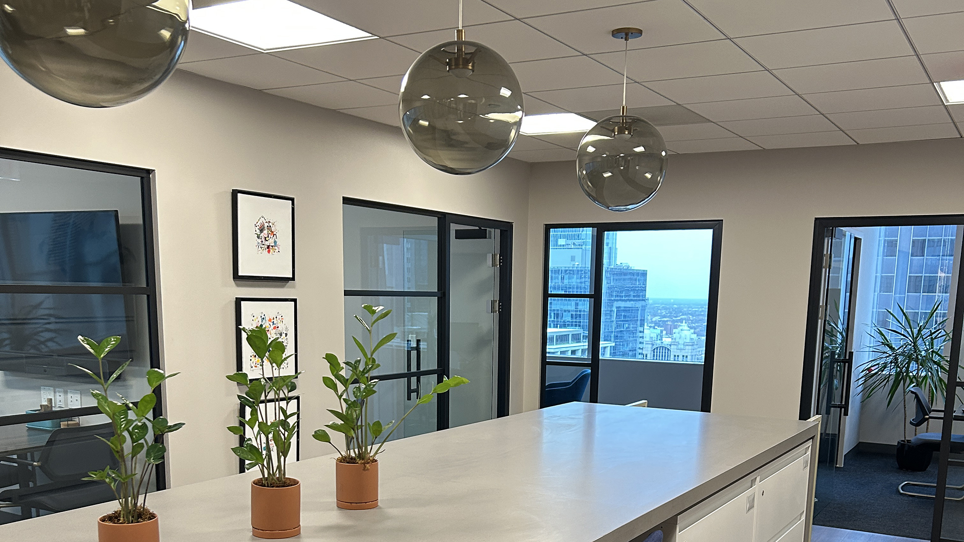 Common area with plants, circular lighting and a white table at at 10 S LaSalle in Chicago IL 