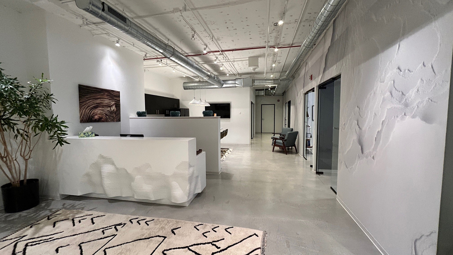 Interior front office with marble walls, black and white carpets, and plants at 125 S Clark 