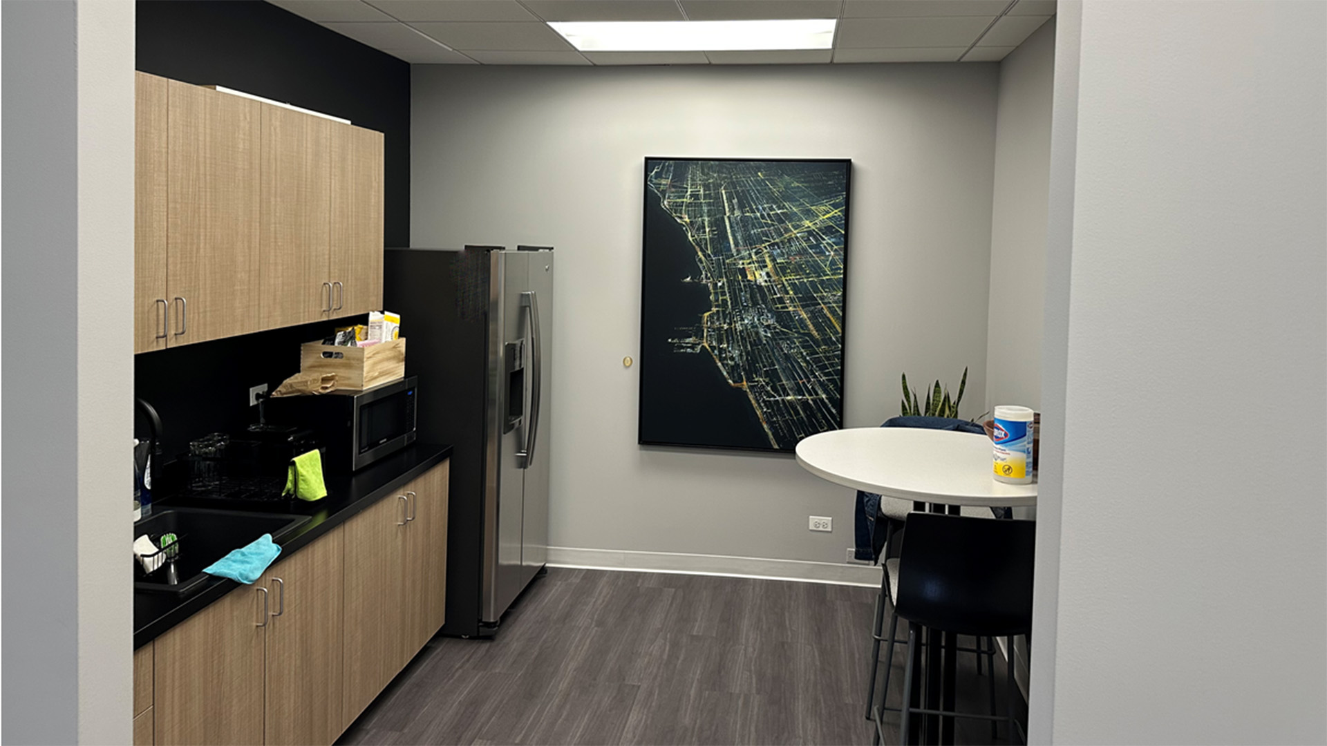 Interior kitchenette space with a a table and art work of the city at 150 N Wacker