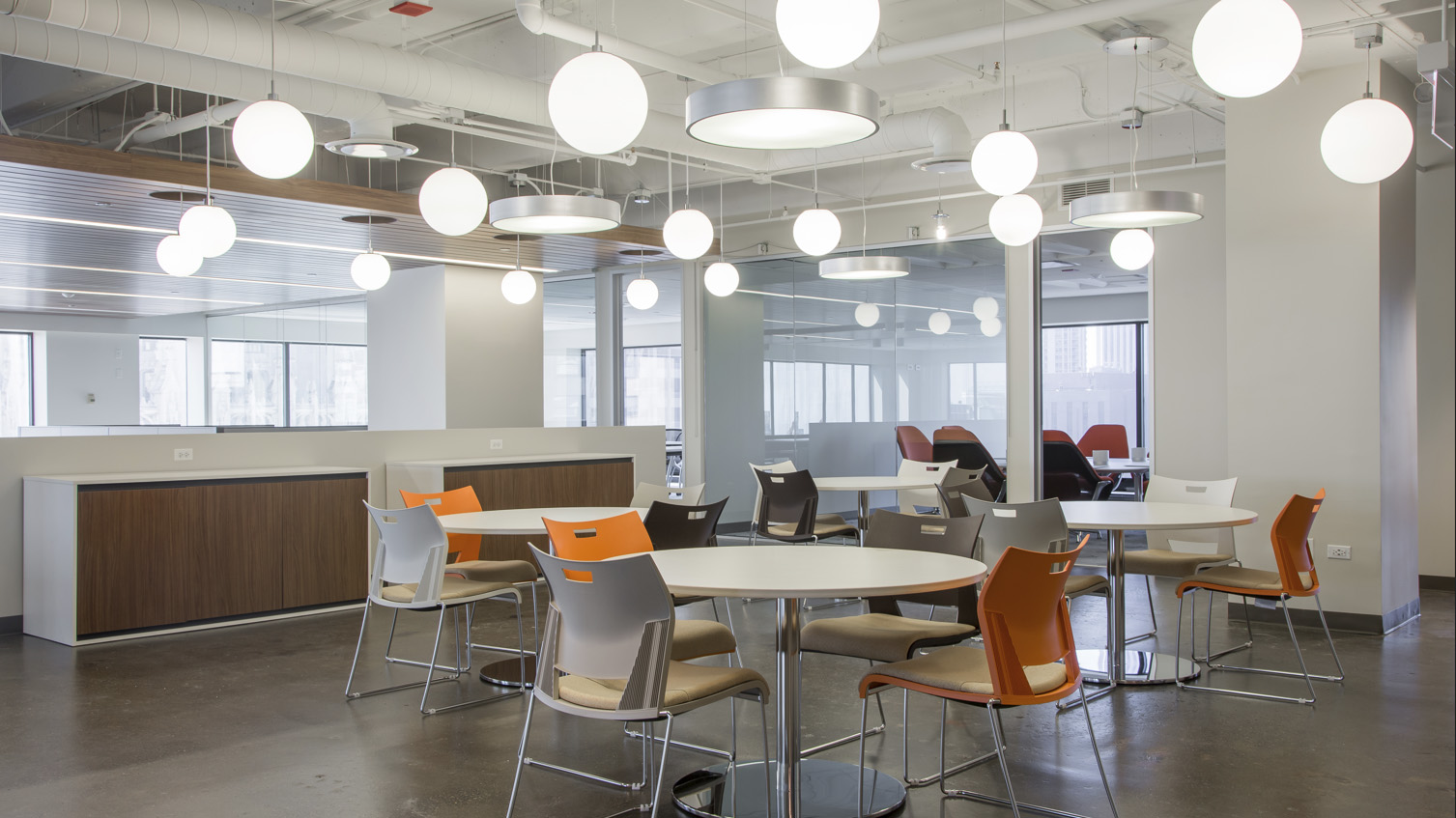 Kitchen area with tables, orange chairs, and unique lighting at 444 N Michigan