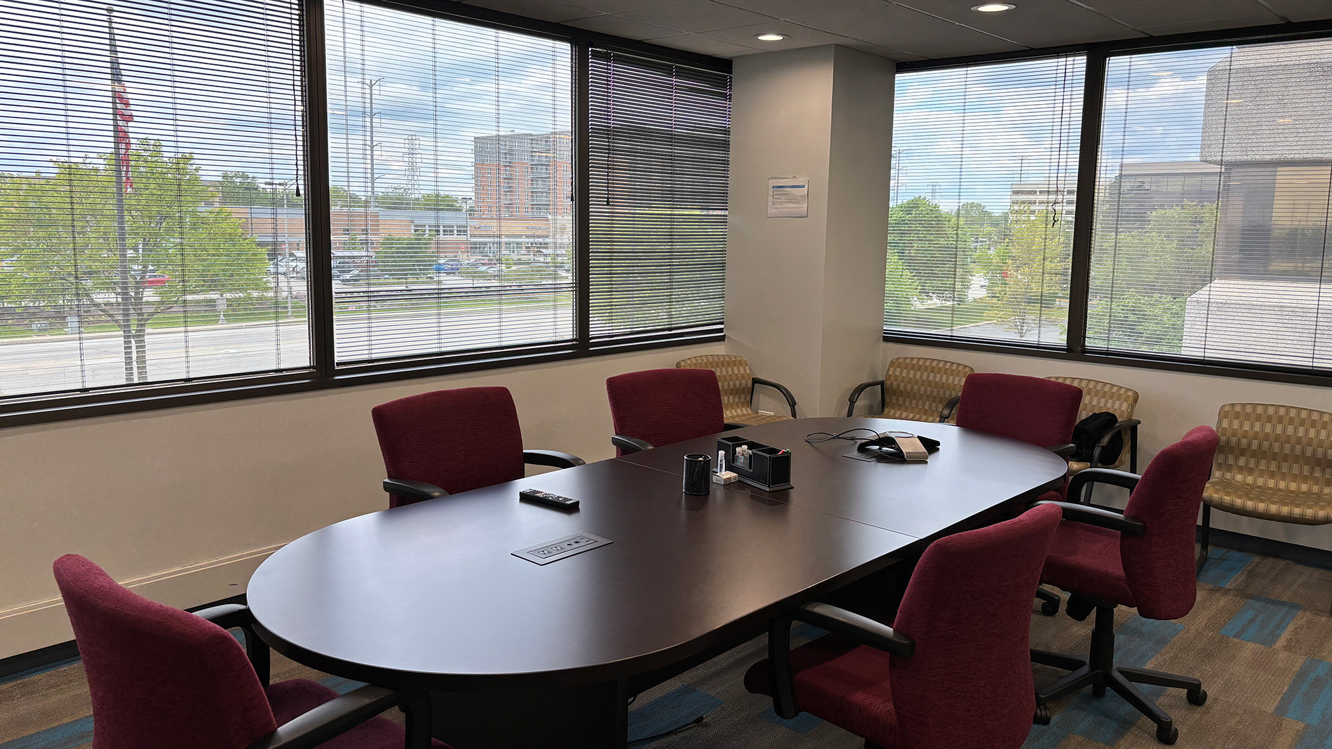 Conference room with dark conference table and maroon chairs with tall windows at 707 Skokie Blvd