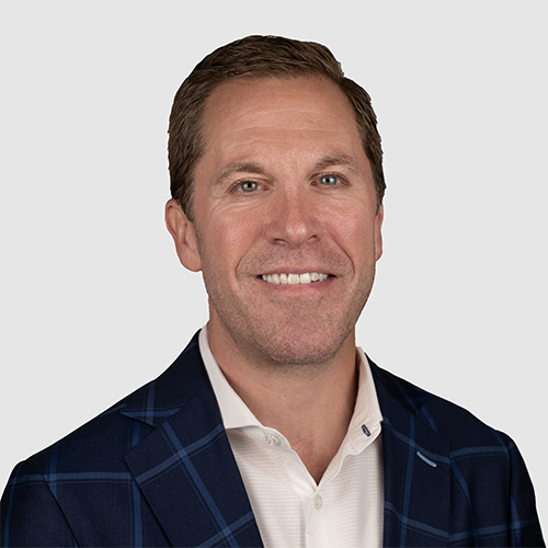 Headshot of Justin Kessler, Senior Vice President at Cresa Chicago, smiling at the camera while wearing a black jacket and white button down shirt
