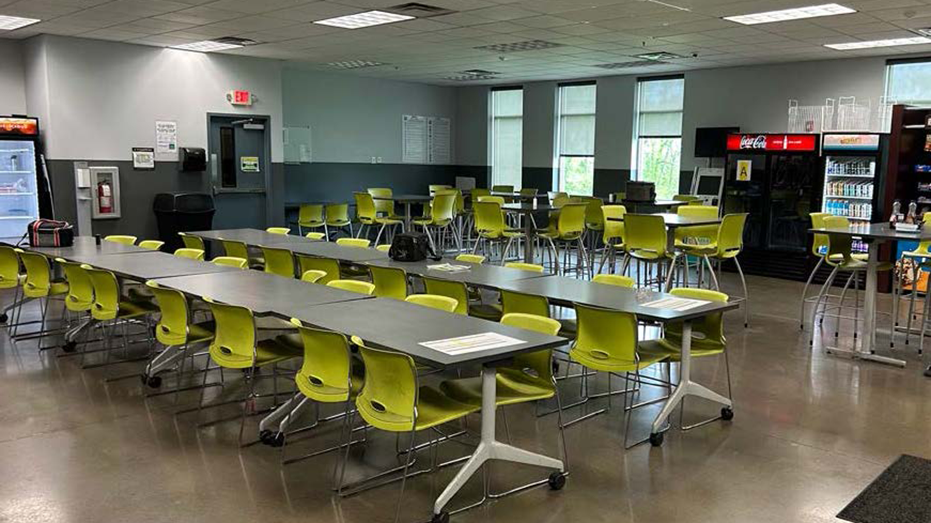 breakroom with long tables, short tables, chairs, and fridges at 715 beechcroft rd