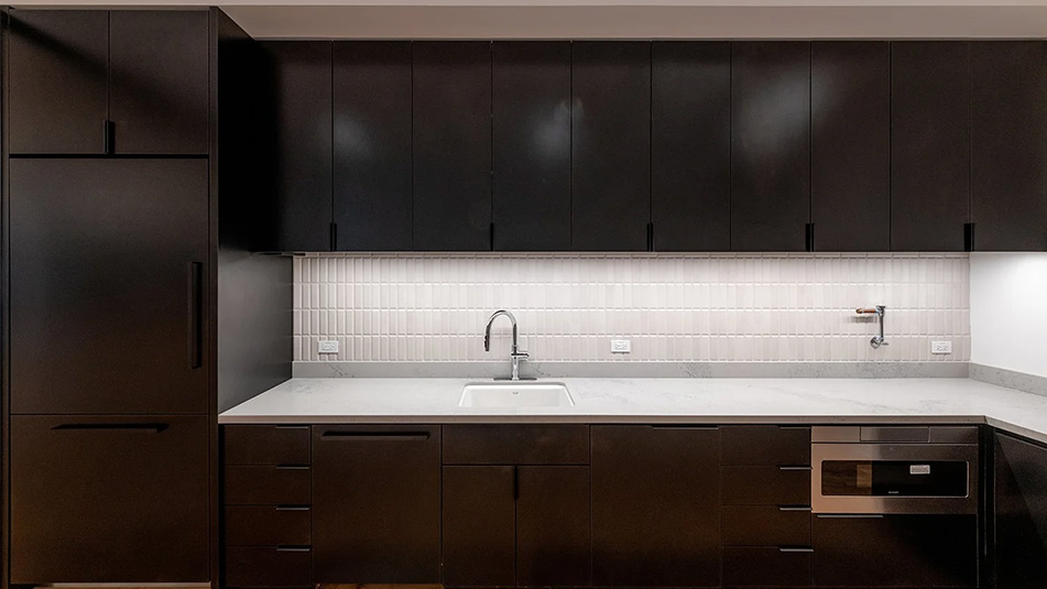 View of the kitch with white counters and dark wood cabinetry