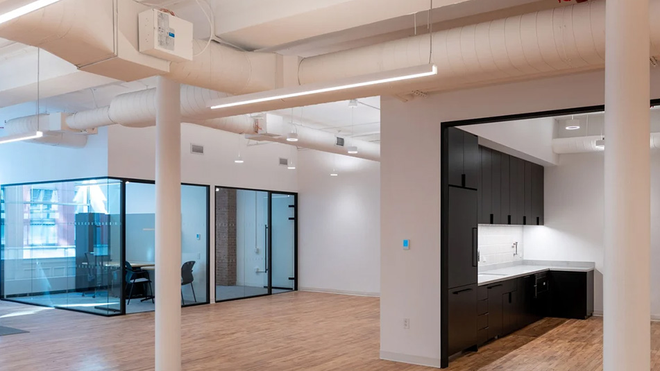 View of glass walled offices with side view into the kitchen